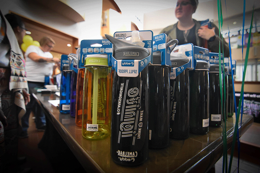 A table is filled with Clarkson Ignite water bottles of various colors