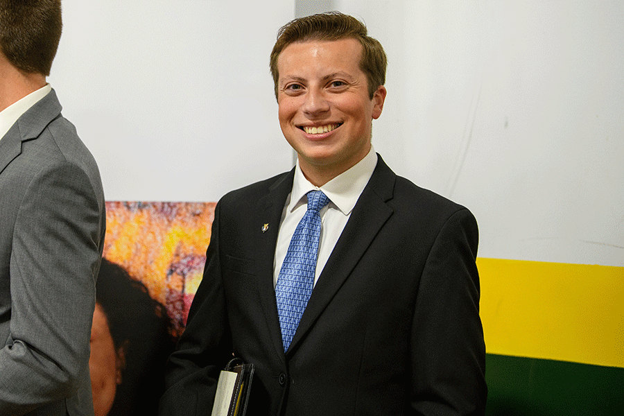 Clarkson student Miles Compani smiles at the camera while wearing a suit and tie